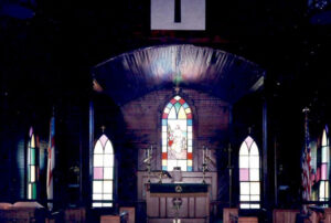 Stained glass windows behind pulpit in church