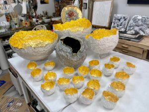 Table full of small and large golden porcelain orbs