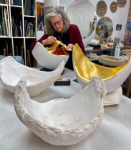 Michaele Rose applying 24K gold to inside of belly sculpture