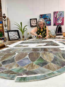 Michaele Rose Watson working on old church stained glass panel