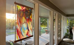 Framed art glass hung in large window