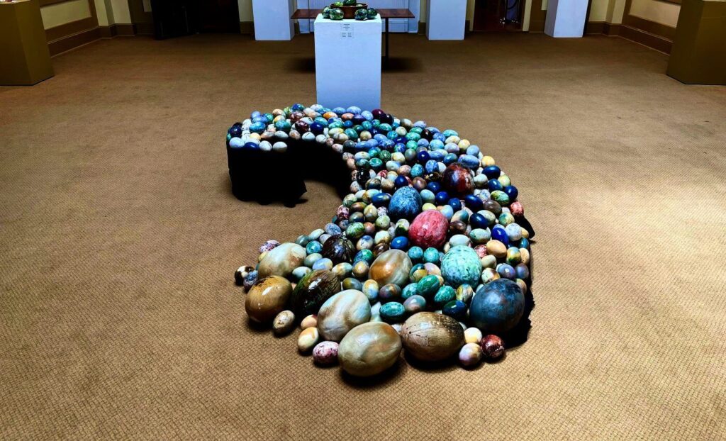 Colorful clay eggs laid out in a comma shape