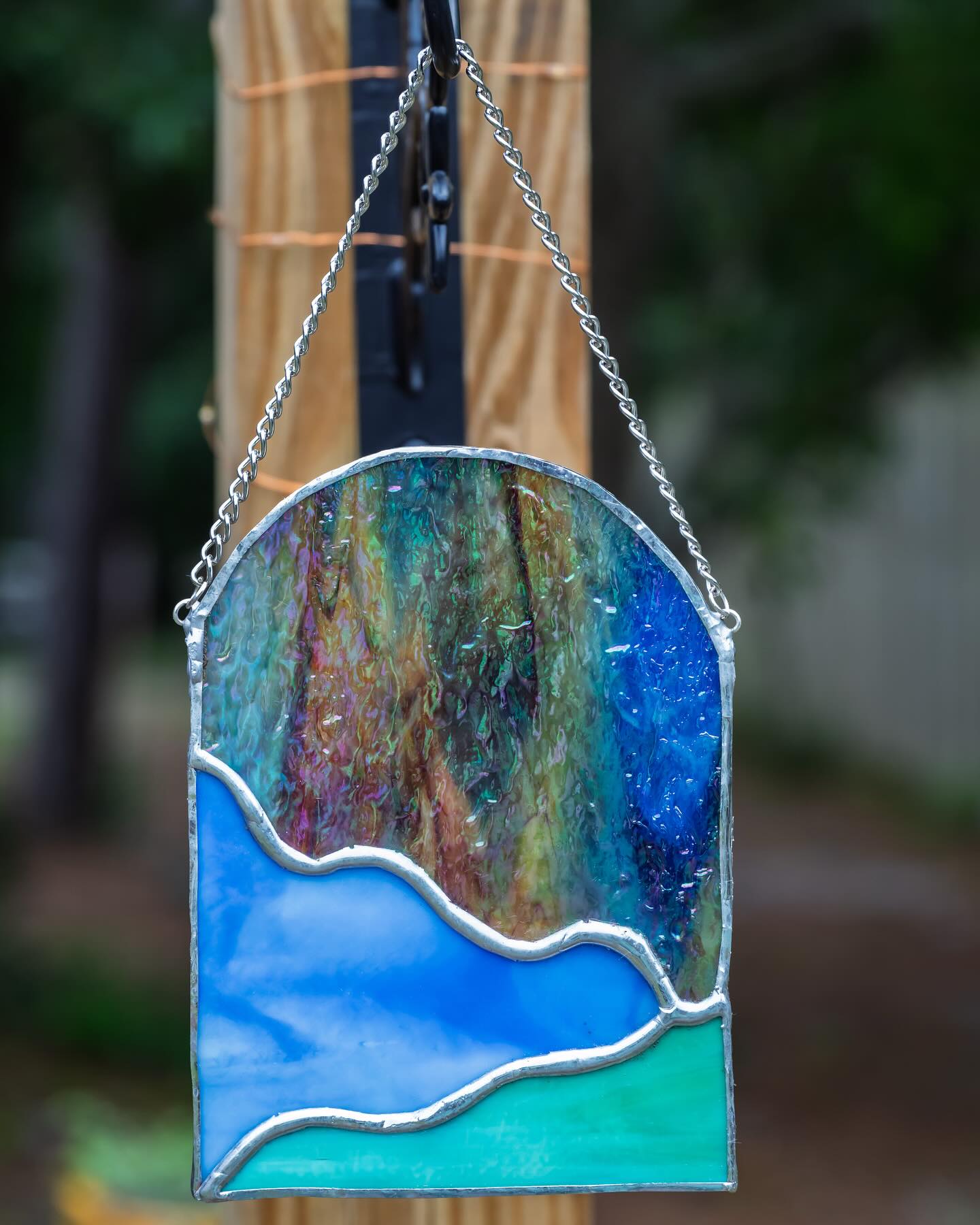 Stained glass mostly in blues on a chain